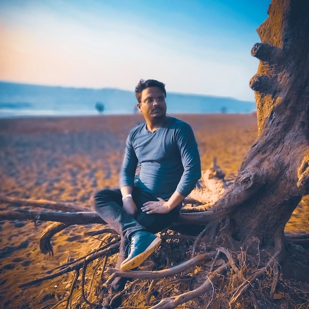 Relaxed male meditating in a serene park, embodying peace and wellness.